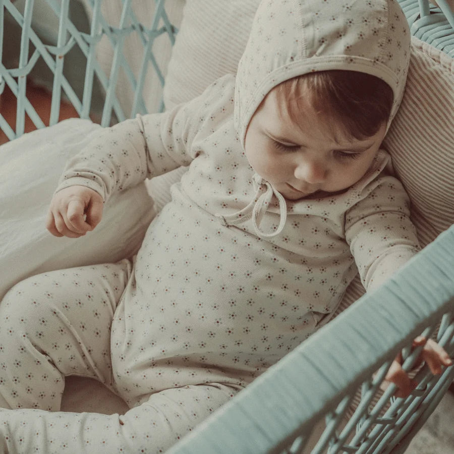 Baby wearing the Lovely Littles Blue Roseberry romper and bonnet