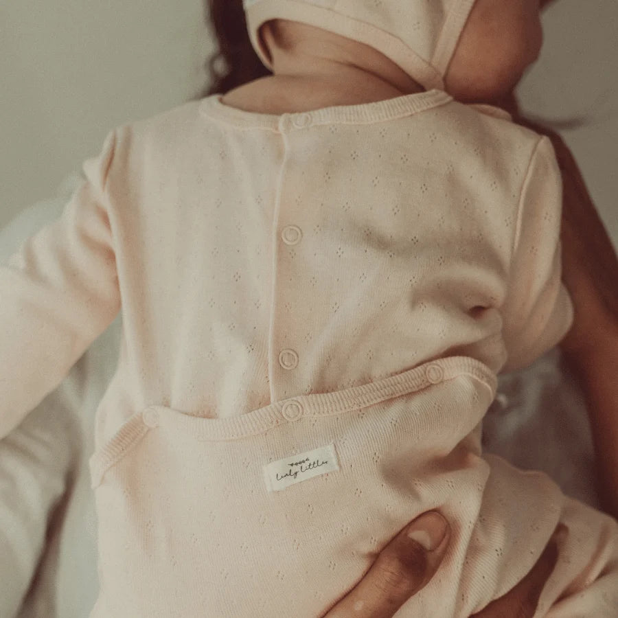 Baby wearing the Lovely Littles Tea Rose pointelle romper