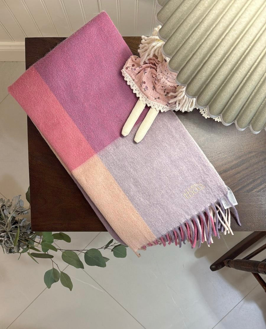TBco Pink Block Check baby blanket styled in a nursery