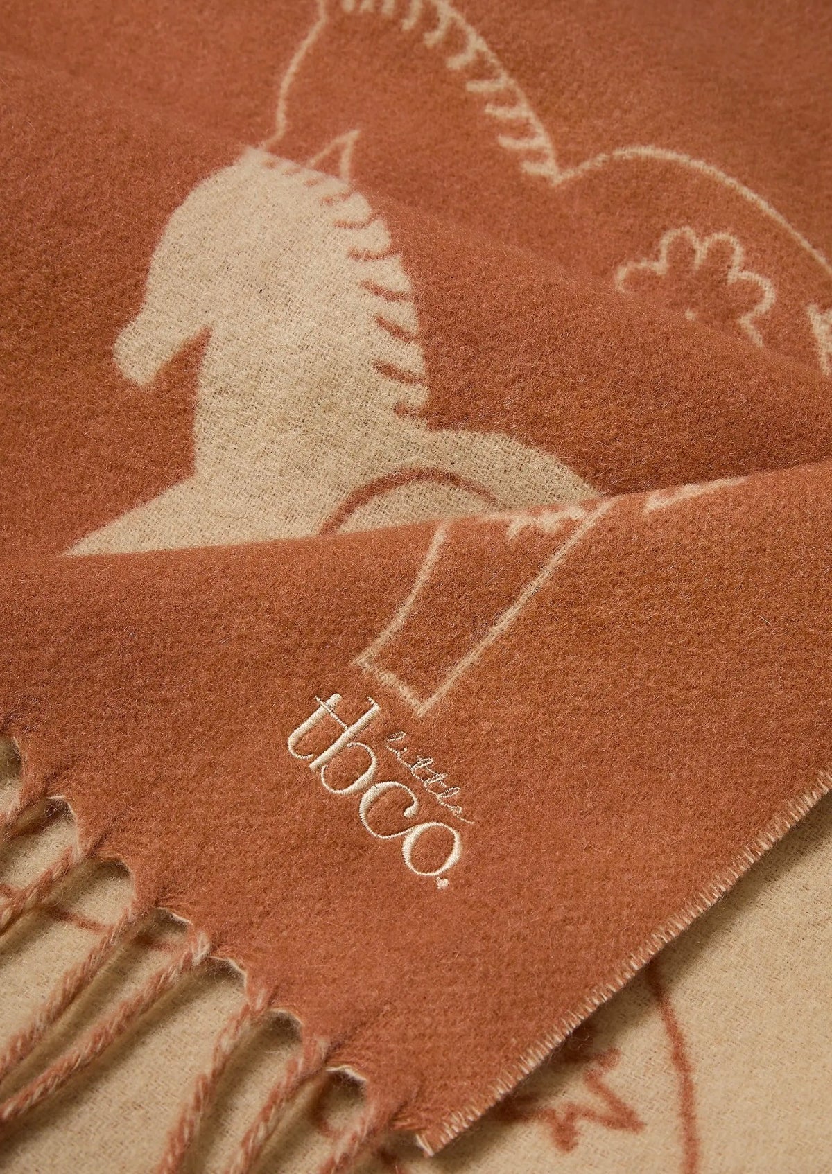 Close-up of TBco Rust Gallop baby blanket