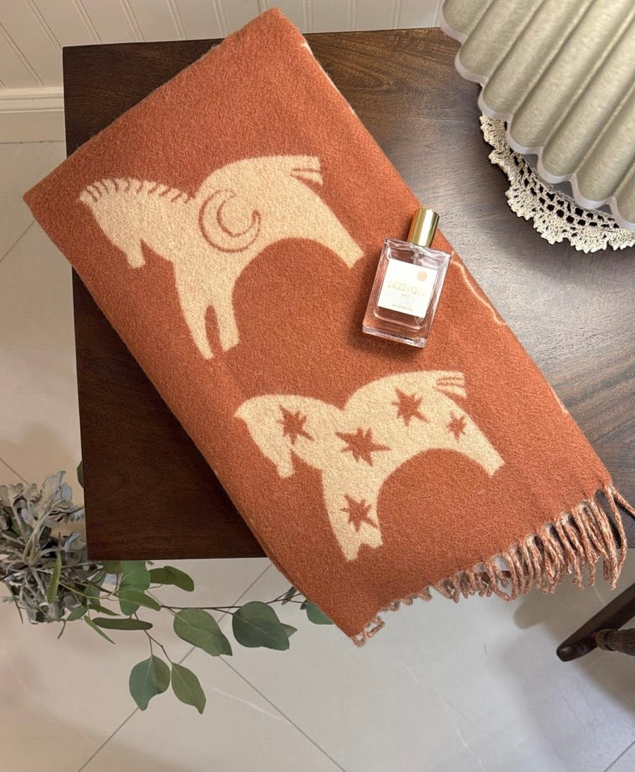 TBco Rust Gallop baby blanket styled in a nursery