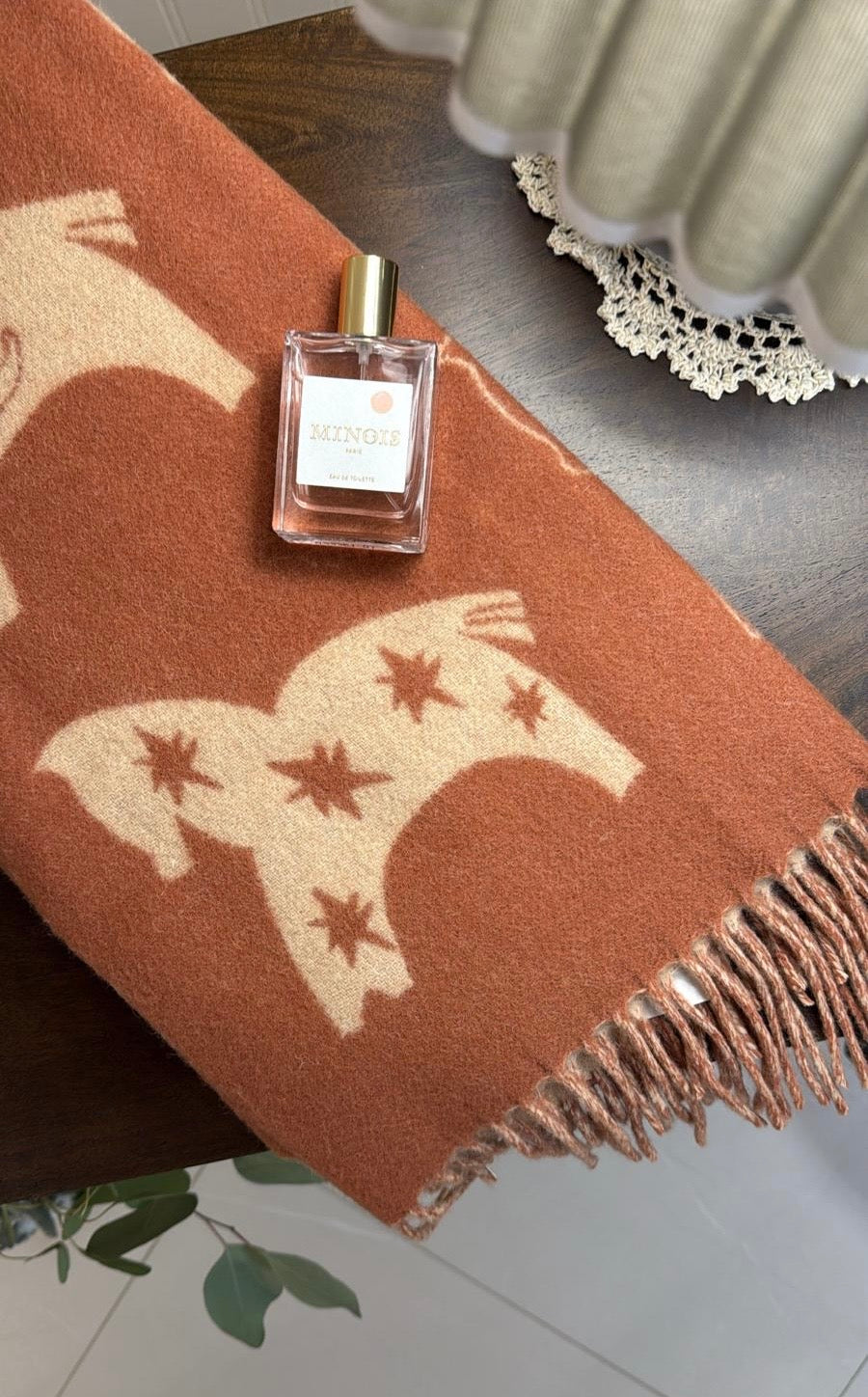 Styled close-up of TBco Rust Gallop baby blanket