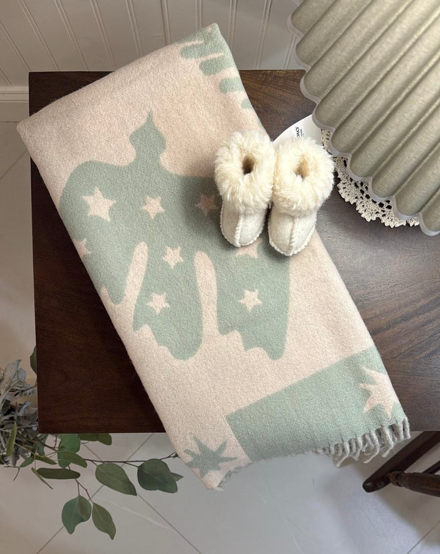 TBco Sage Folk baby blanket styled in a nursery